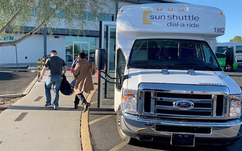 Sun Shuttle van drops off passengers in front of building